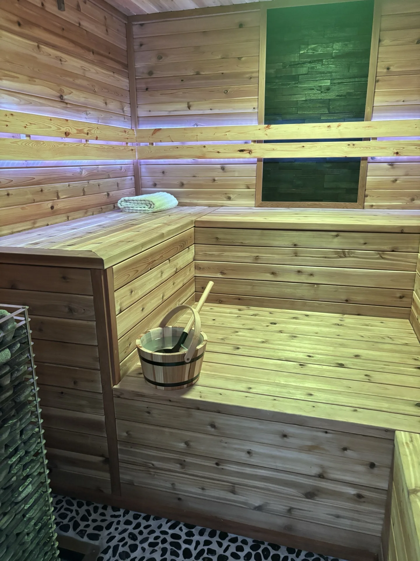 Sauna interior in natural warm light with cedar bench and water bucket
