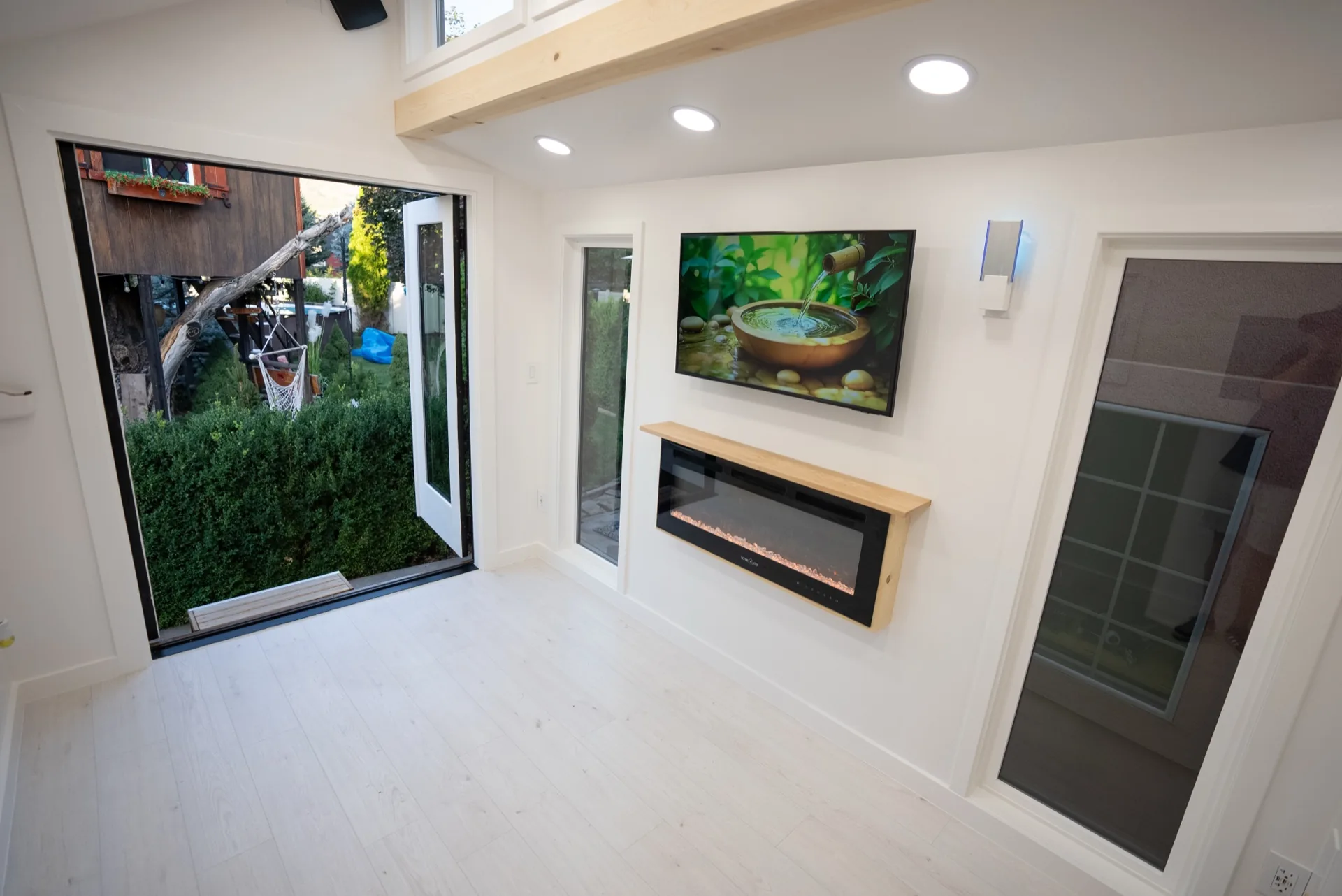 Open glass doors connecting the lounge to the garden